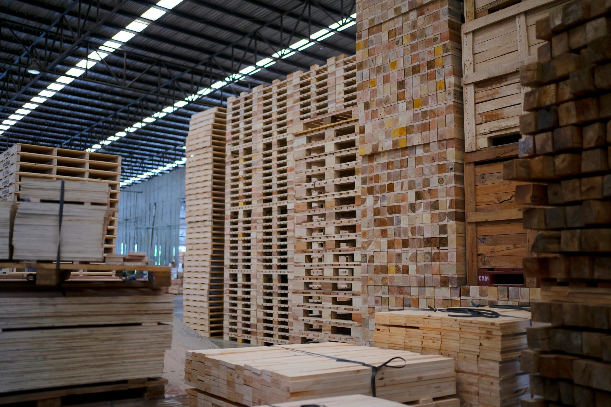 Workers repairing wooden pallets in a production facility